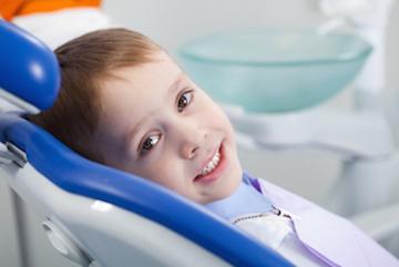 A smiling child sitting in the dentist's chair