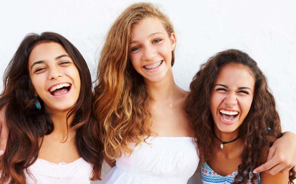 A group of smiling girls against a white background