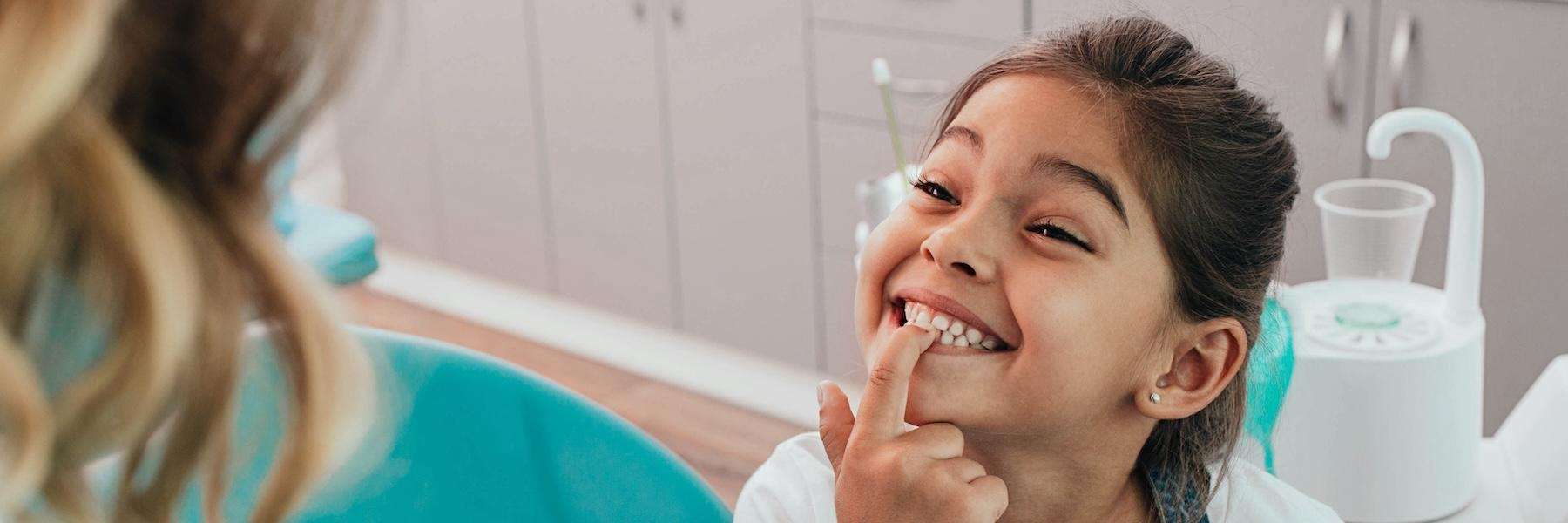 A smiling girl showing her dentist her teeth | corona children's dentist