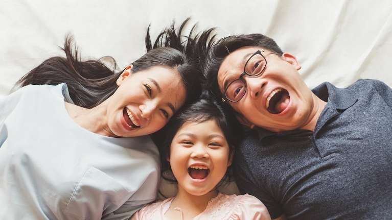 A smiling family in bed