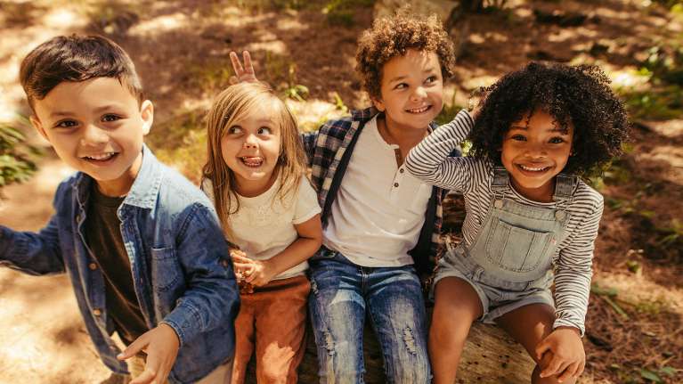A group of smiling children in the forest