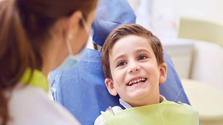 kid smiling at dentist in Corona