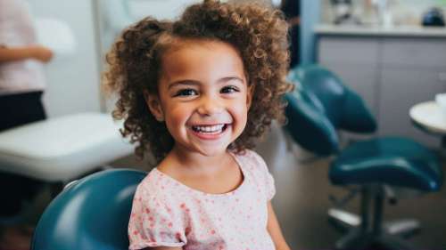 A smiling girl sitting in the dentist's office