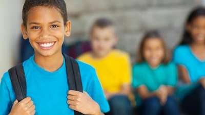 A smiling child with a backpack