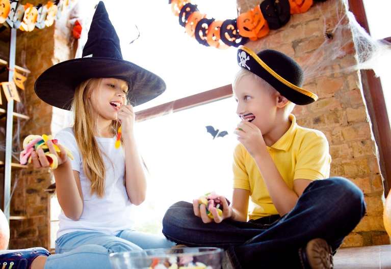 Two children eating Halloween candy