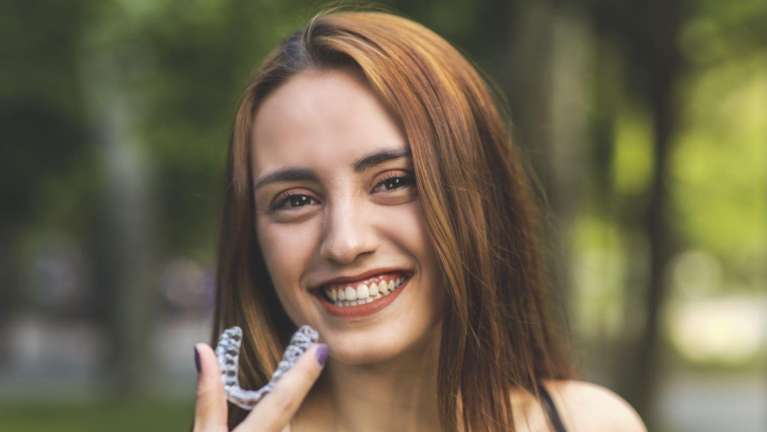 woman with Invisalign clear aligners