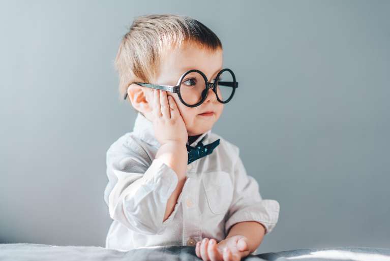 A child wearing large glasses and a bowtie