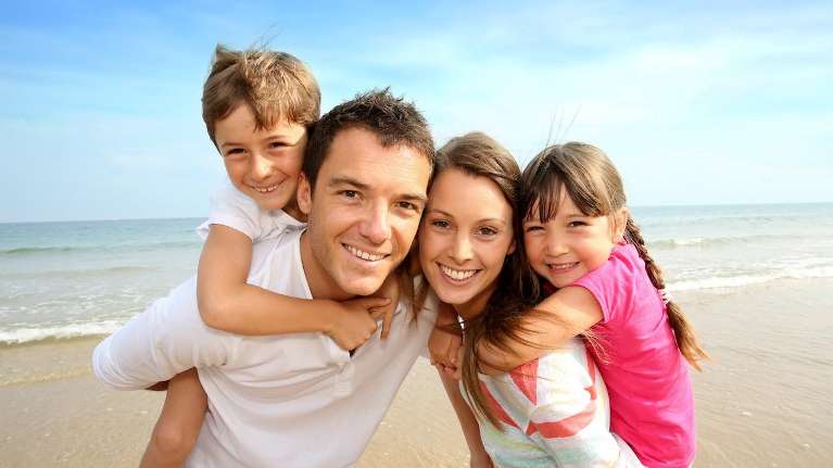 family smiling at the beach, Corona CA