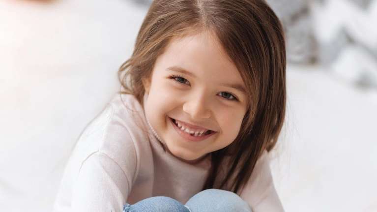 A smiling girl with a missing tooth