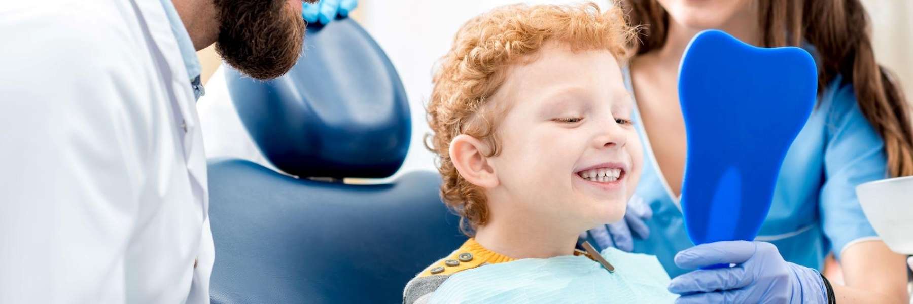 A dentist showing a child his teeth during a dental appointment