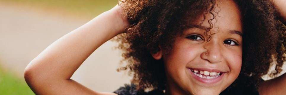 Young girl smiling with hands in her hair, Corona CA